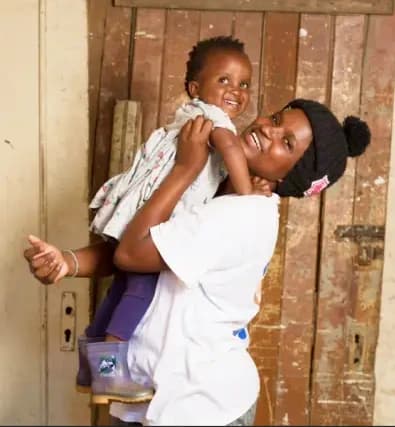 A mother joyfully holding her young child