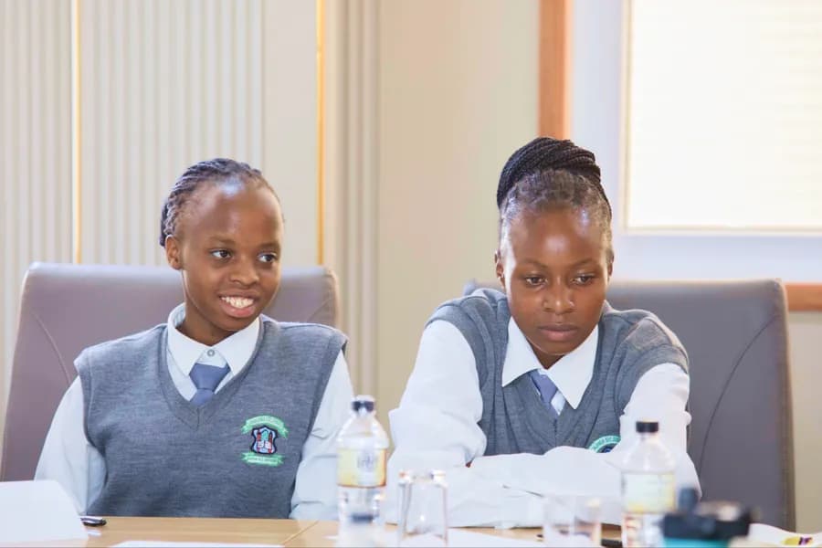 Two students seated at a desk during a Surround Sound Kenya engagement