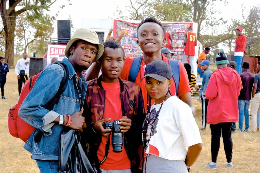 A group of young people at a Shujaaz festival, one holding a camera